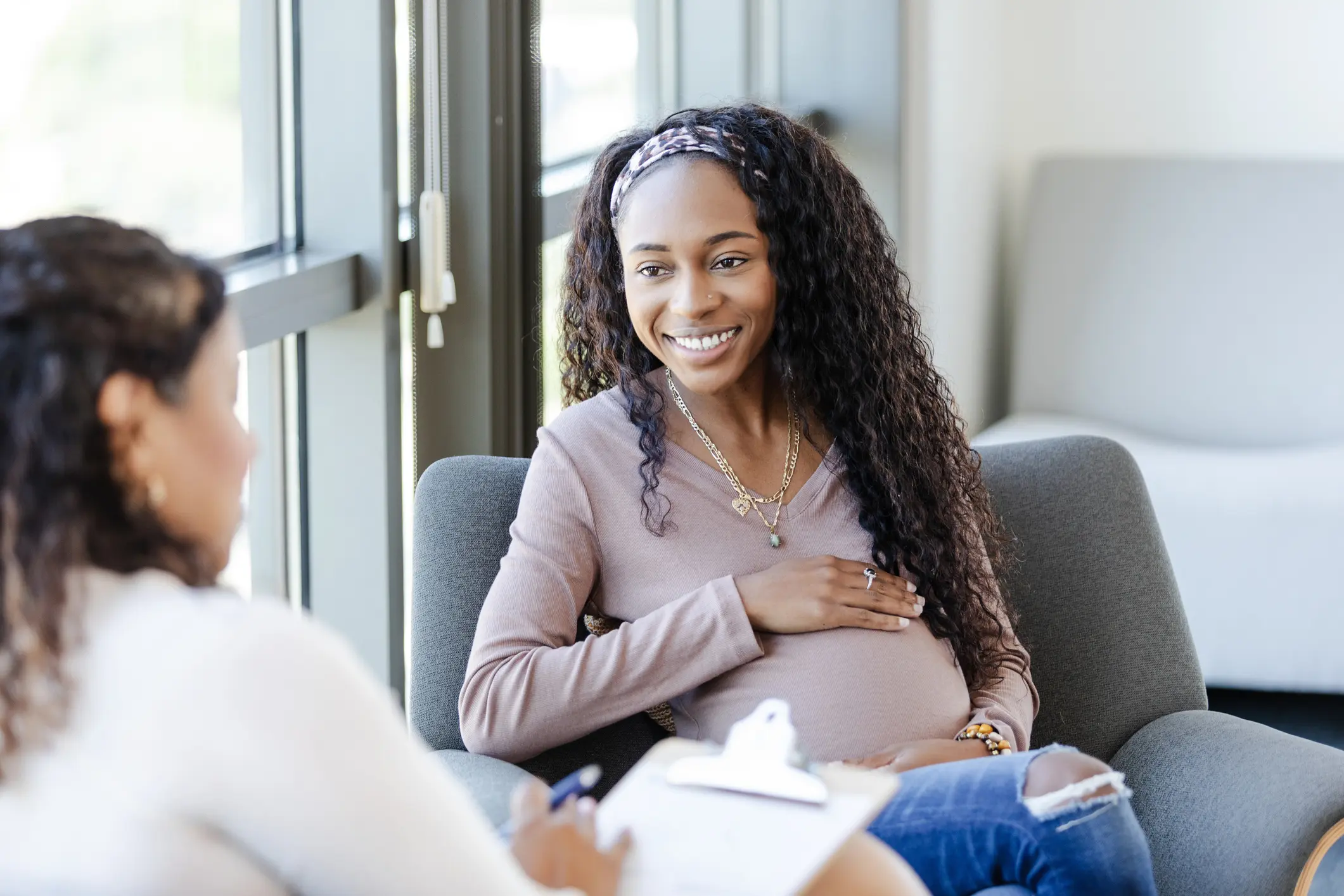 Pregnant woman smiling during a consultation.