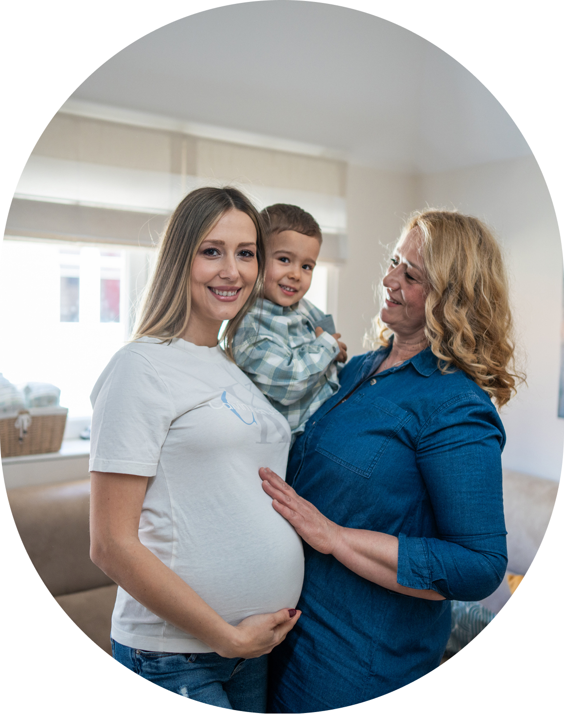 Pregnant woman with family smiling indoors.