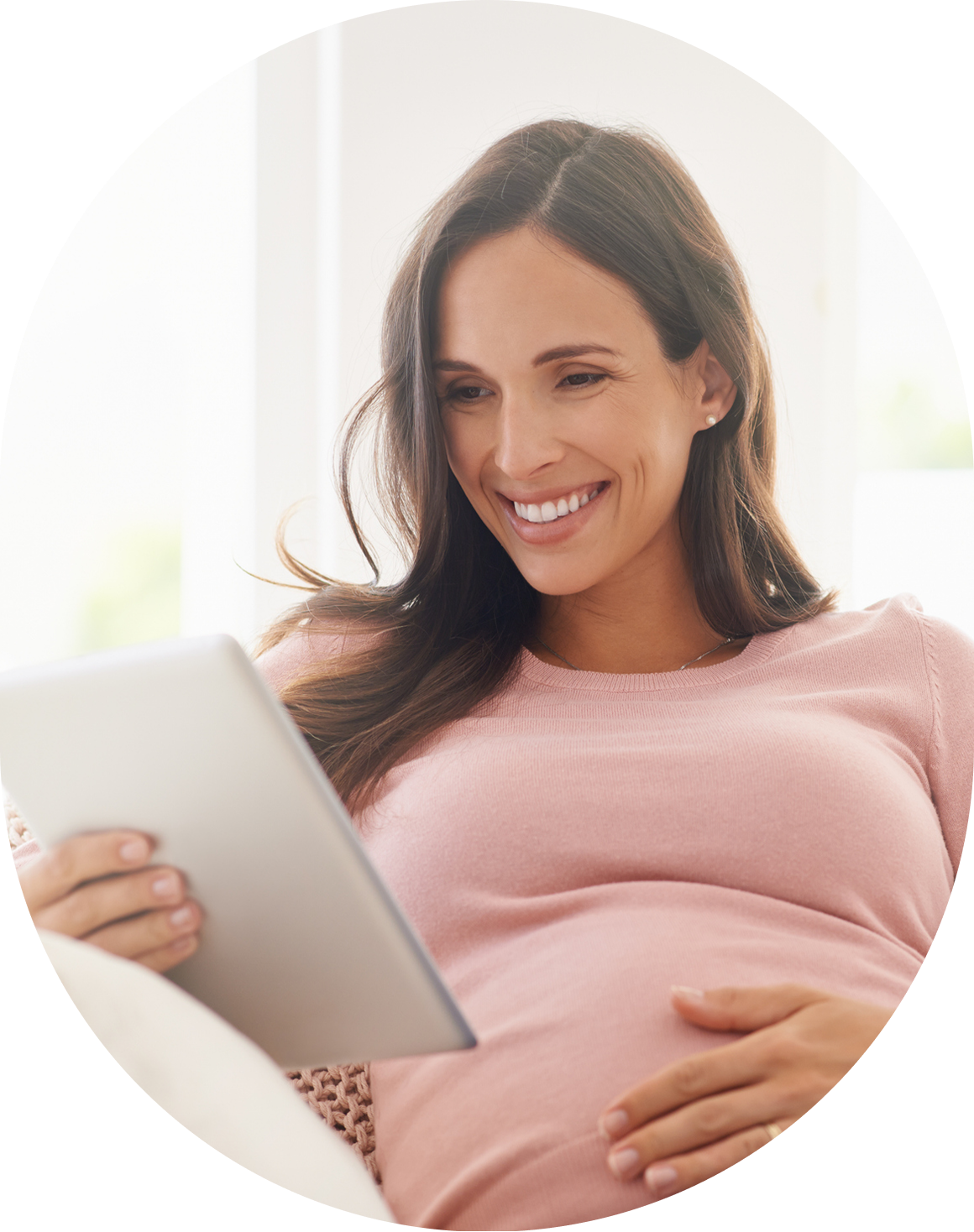 Pregnant woman smiling at tablet